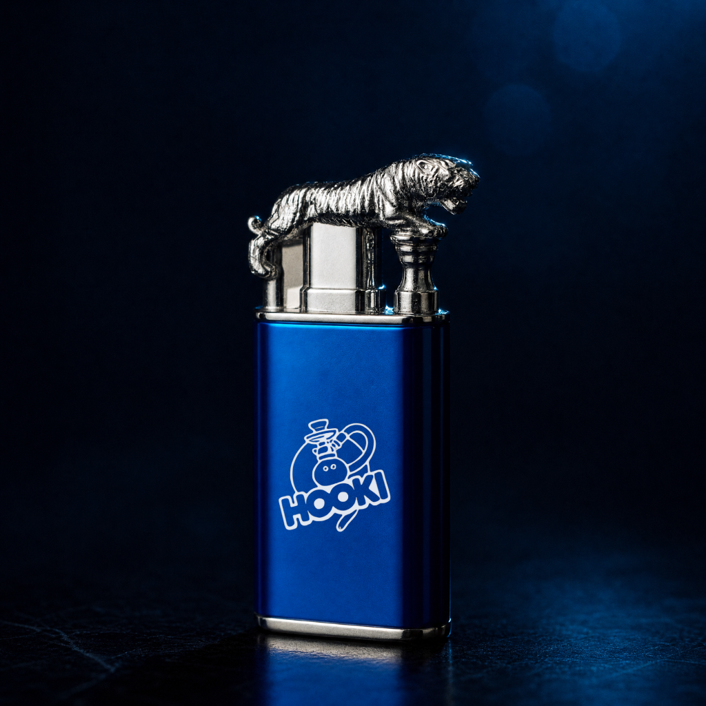 A blue metal lighter with a silver tiger figurine on top and a white HOOKI logo on the front, photographed against a dark blue studio background.